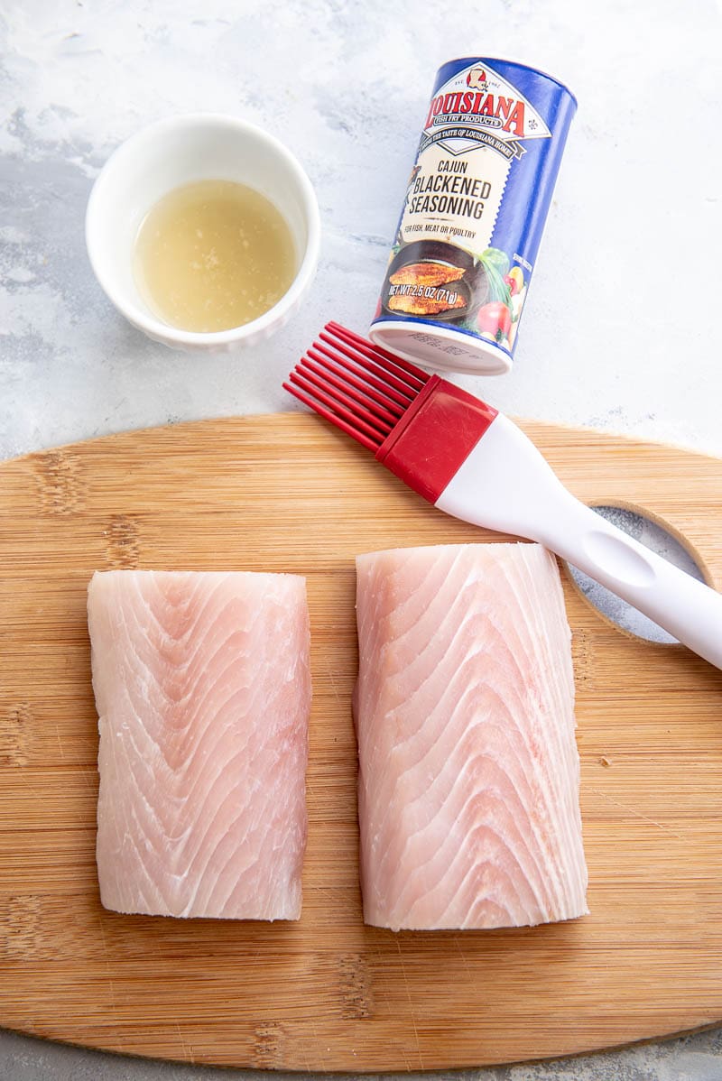 raw mahi mahi on a wood plank with prep