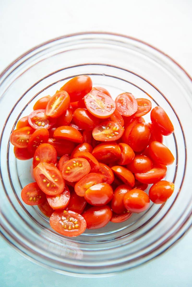 sliced grape tomatoes in a glass bowl