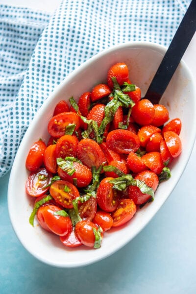 balsamic tomato salad in a bowl with spoon