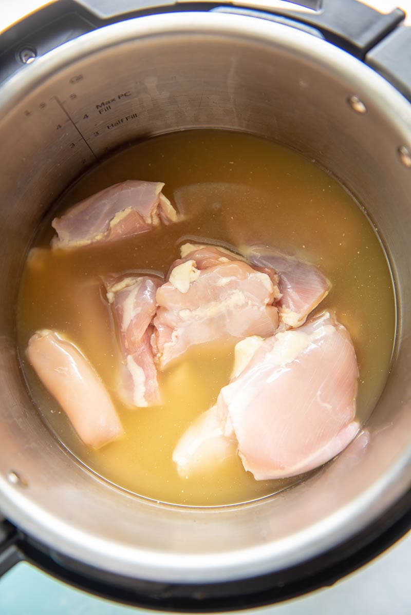raw chicken thighs and broth in an instant pot