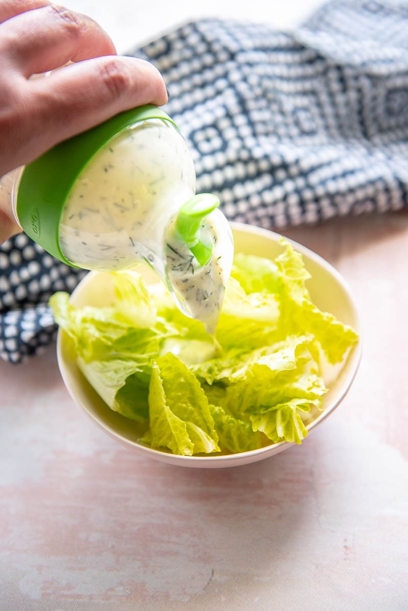dairy free ranch dressing poured on a lettuce salad