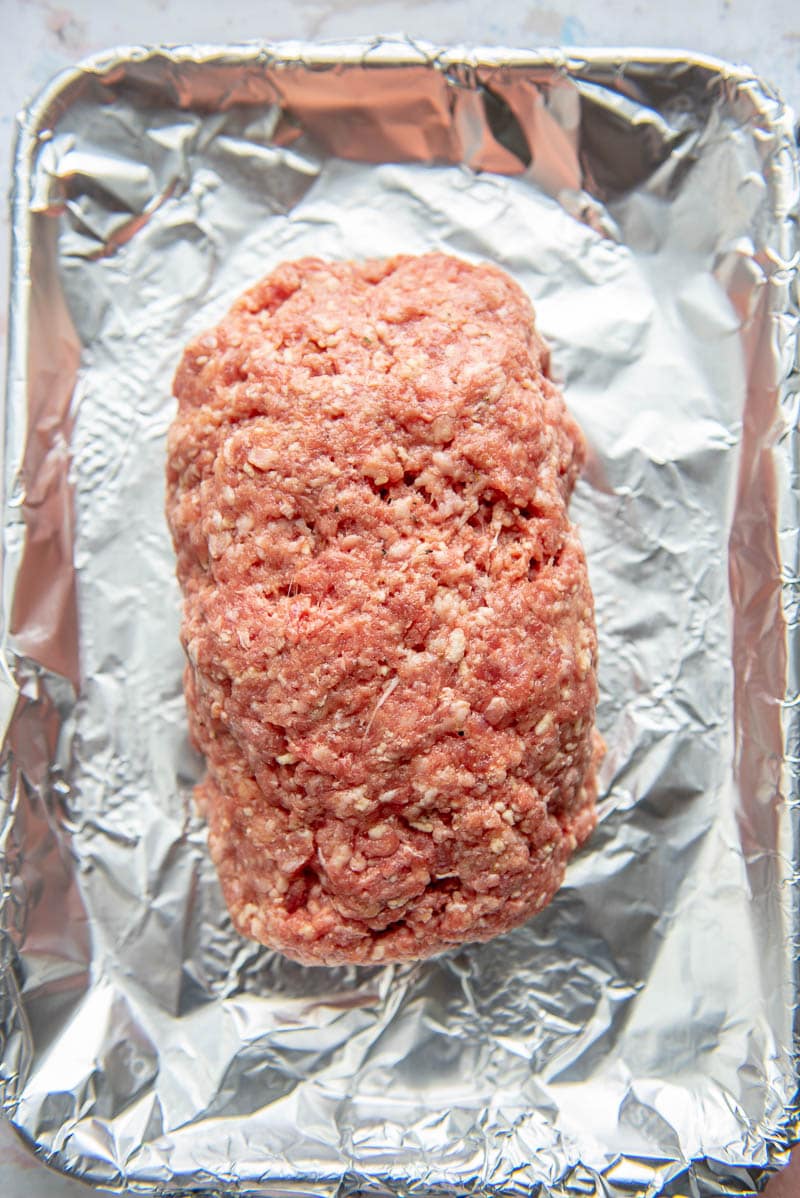 raw meatloaf on foil lined cookie sheet
