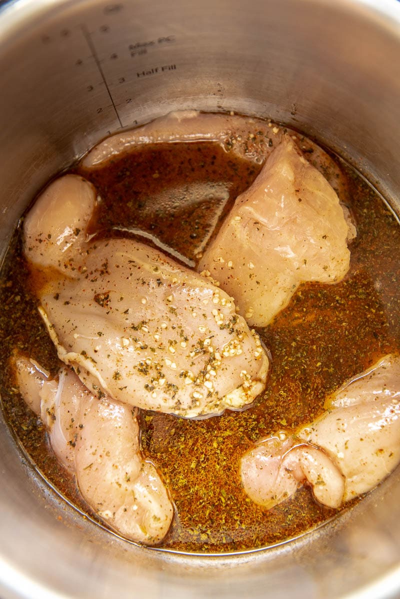 raw chicken breasts and seasoning in instant pot