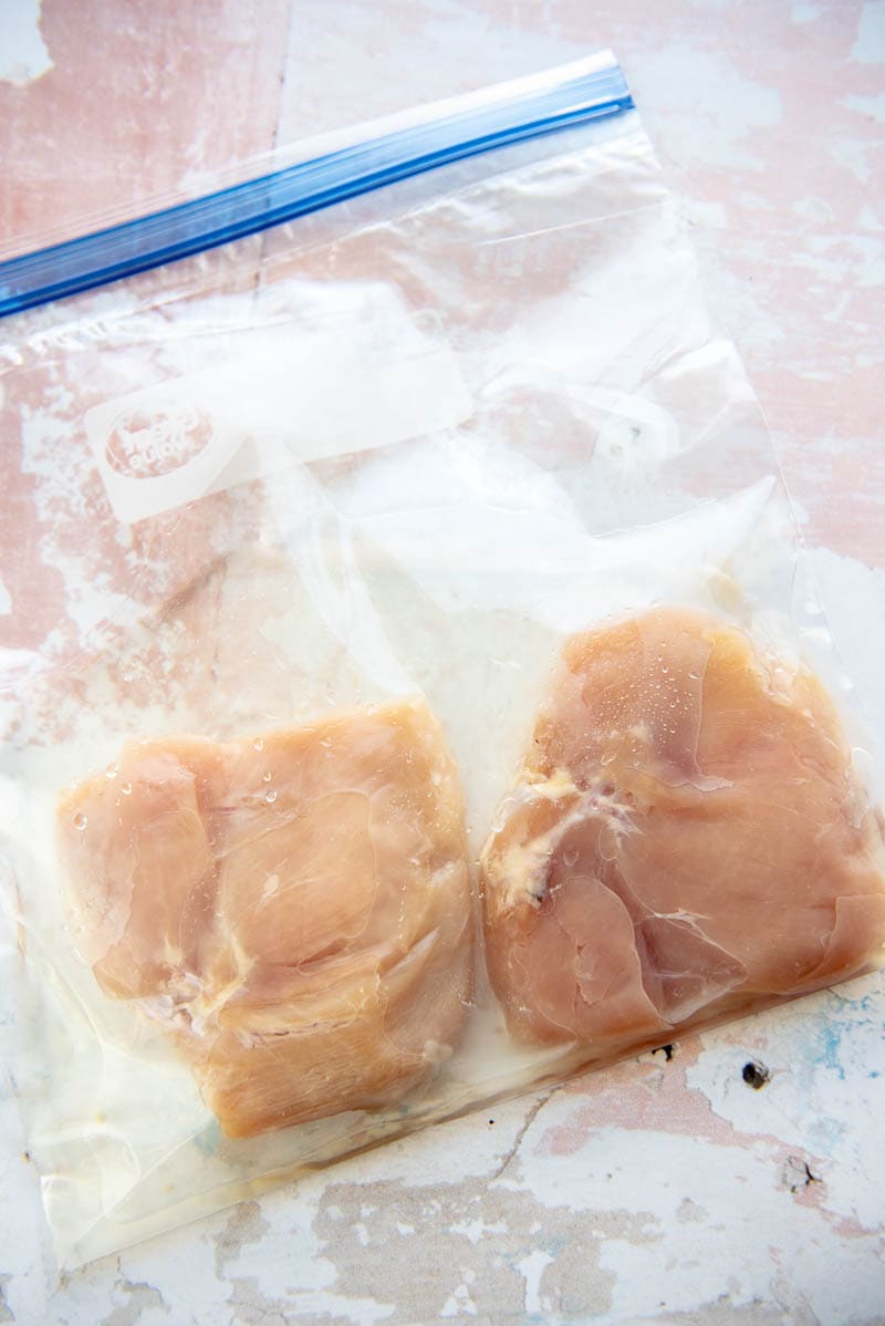 ziplock bag with two chicken breasts marinating in pickle juice