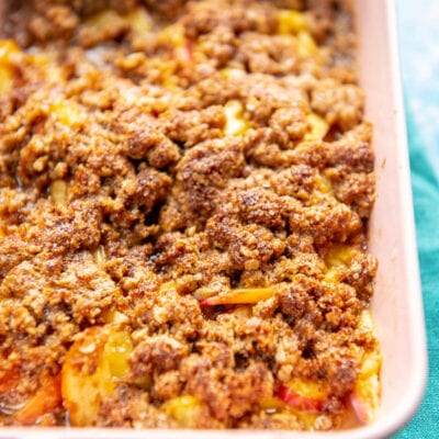 small pink casserole dish with peach cobbler