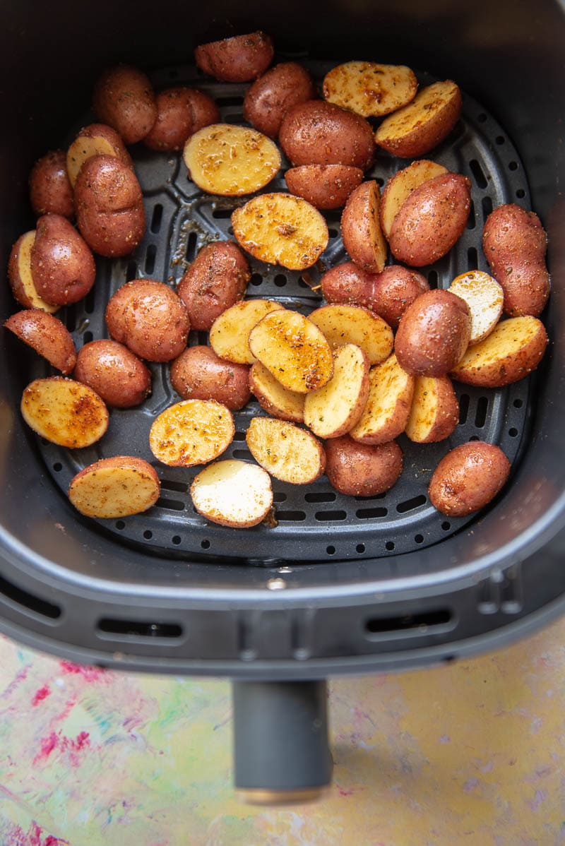 seasoned baby potatoes in air fryer basket ready to cook