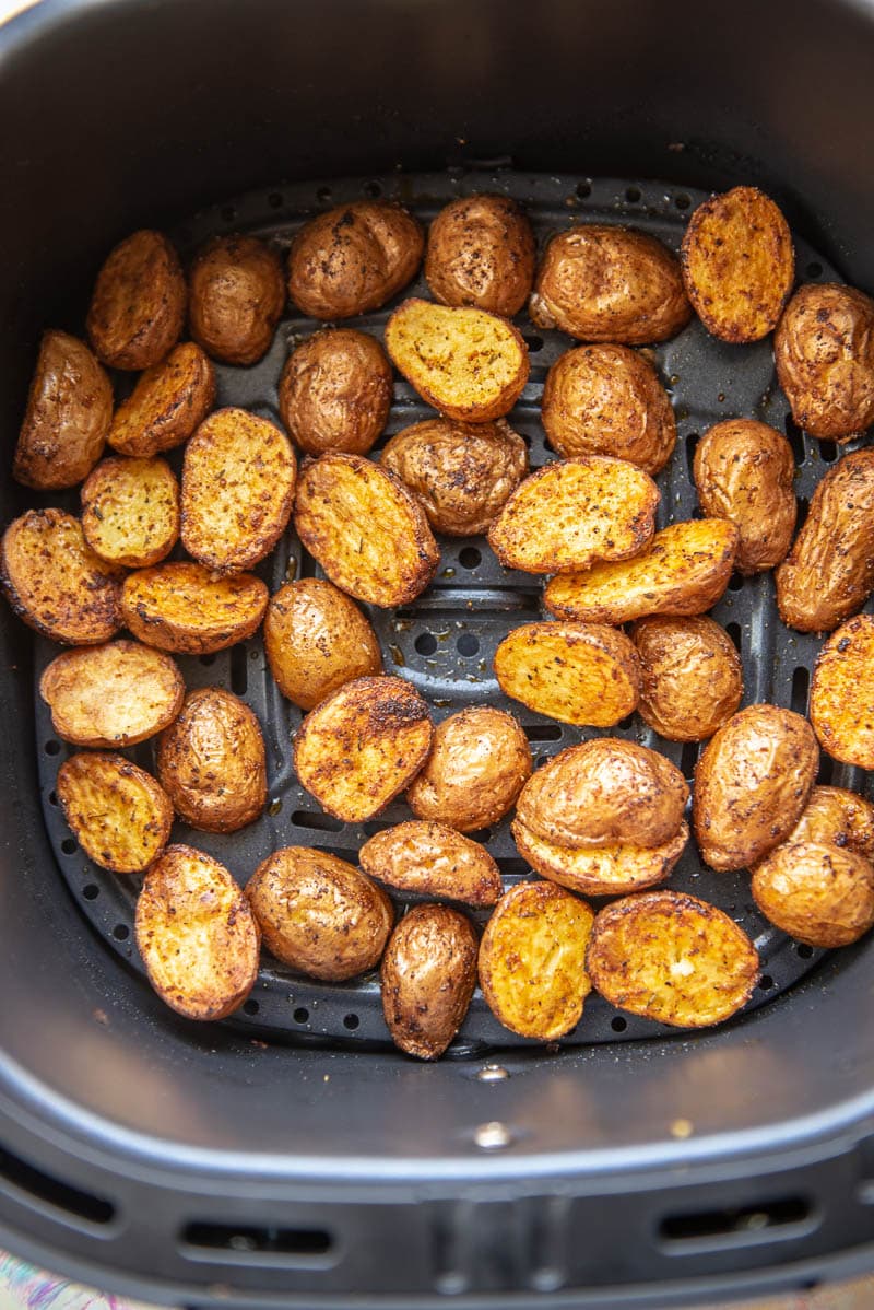 air fryer basket with roasted seasoned red poatoes