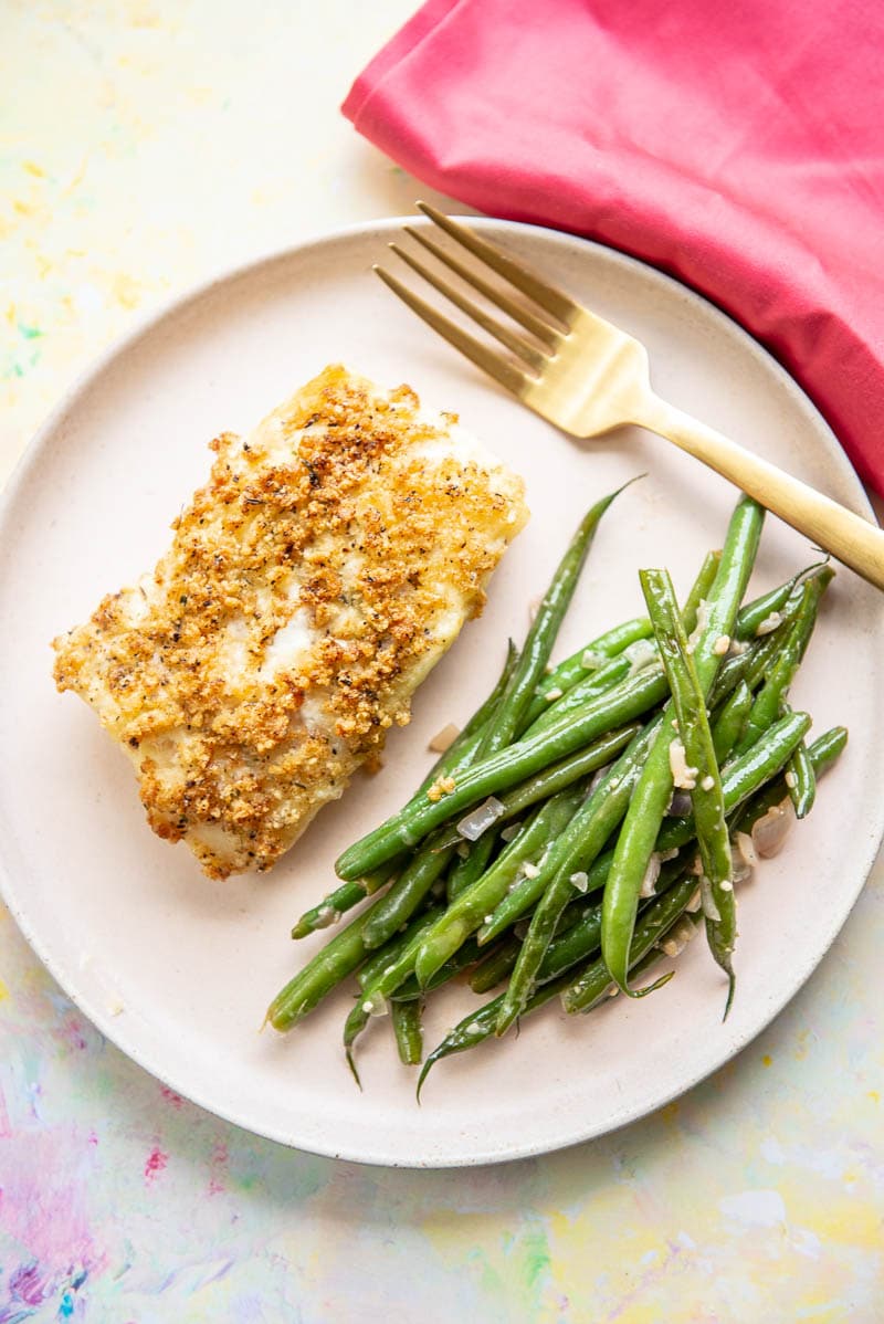 air fryer breaded cod on pink plate with fresh green beans