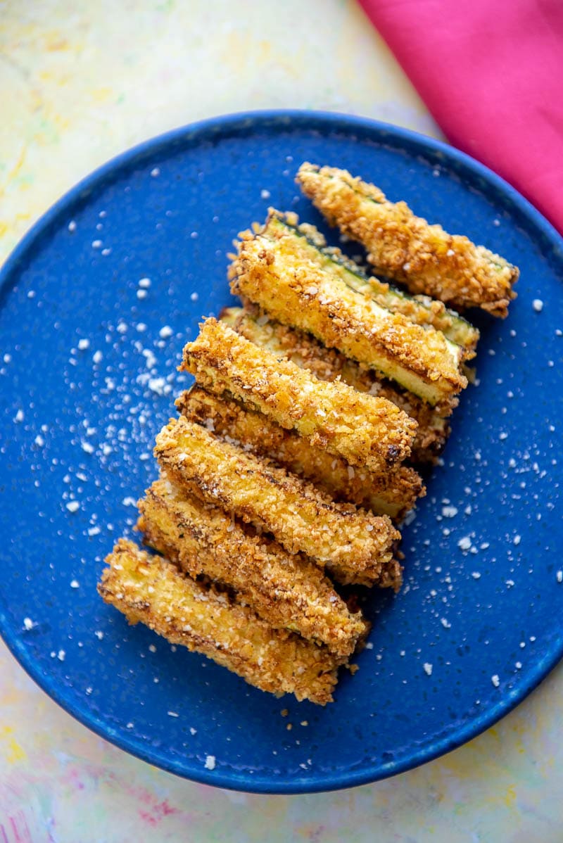 overhead of zucchini fries from the air fryer on a blue plate