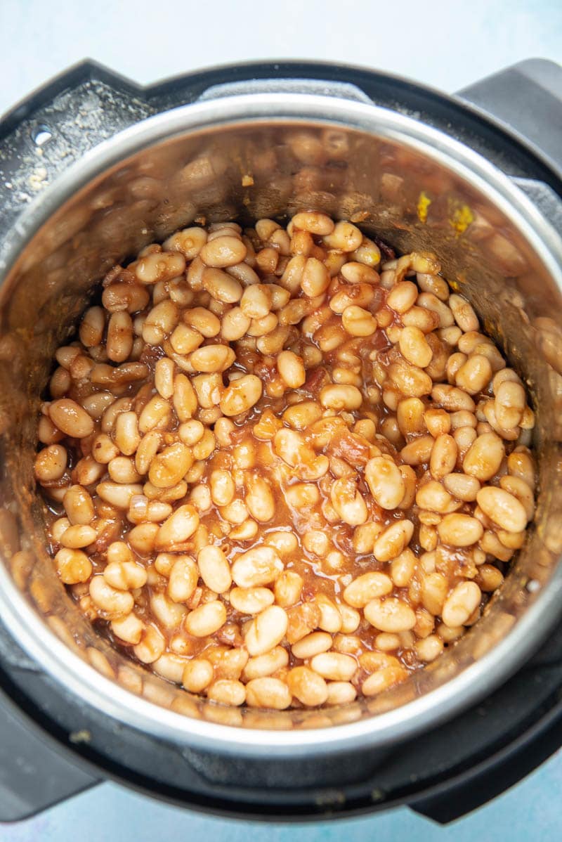 instant pot with beans and sauces ready to cook