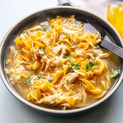 chicken noodle soup in large blue bowl