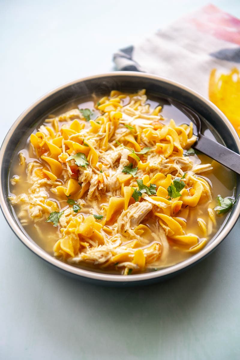 chicken noodle soup in large blue bowl