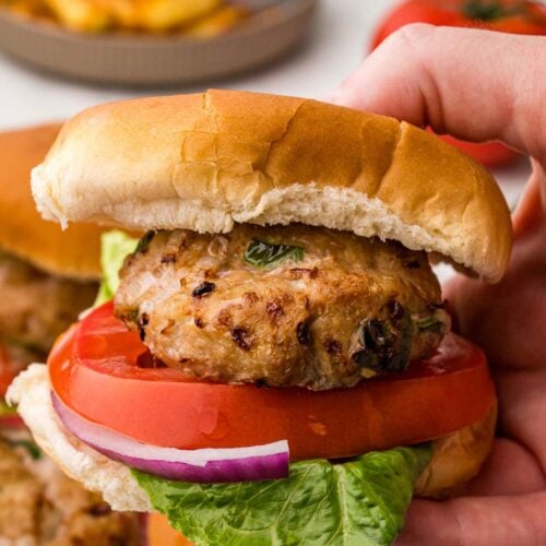 Close up image of Air Fryer Turkey Burger served on a bun with tomatoes, red onions, and lettuce