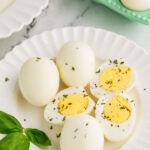 Halved hard boiled eggs garnished and served on top of plate