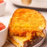 air fryer grilled cheese sandwich cut in half with melted cheese coming out