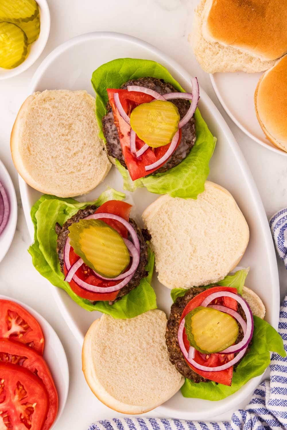 3 Burgers served with tomato, ketchup, red onion, lettuce and the top buns off