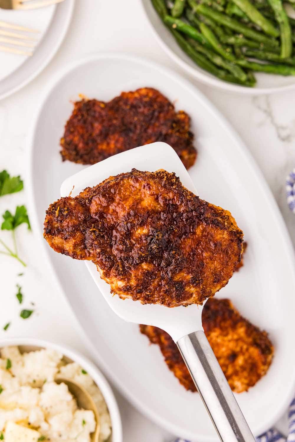 Cooked Air fryer Boneless Pork Chop being picked up by spatula
