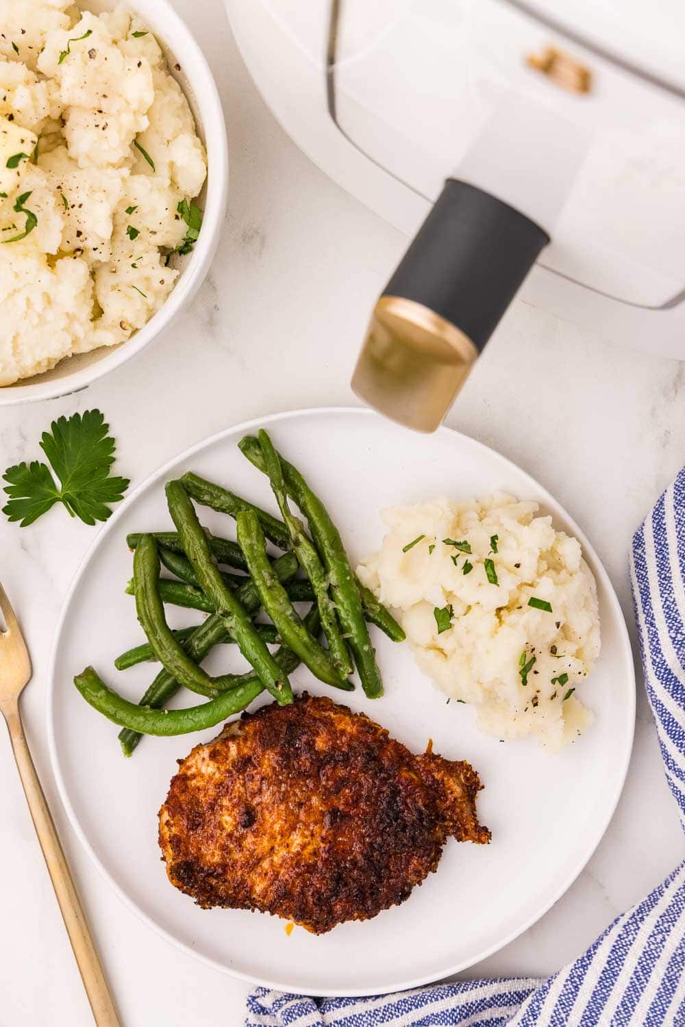 Boneless Pork Chops served with green beans and garnished mashed potatoes