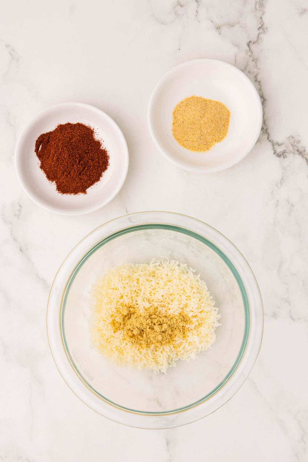 Small bowl of cheese, and 2 smaller bowls with seasonings
