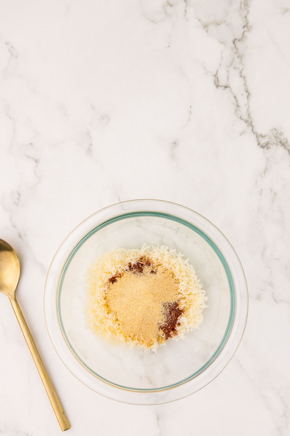 Cheese and seasoning being mixed together in bowl