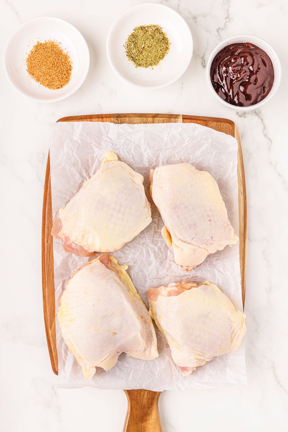4 raw chicken thighs on cutting board