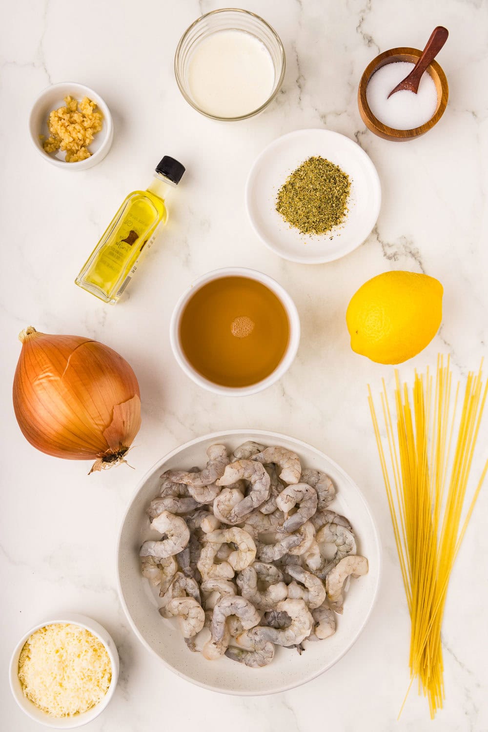 Ingredients like 12 oz angel hair pasta 2 tablespoons olive oil 1/2 cup diced yellow onion 2 teaspoons 12 oz frozen shrimp thawed, peeled, deveined and tail off 1 tablespoon 1/4 cup lemon juice 1 cup chicken broth 1/4 cup heavy cream 1/2 cup Parmesan cheese 1/2 teaspoon salt on counter