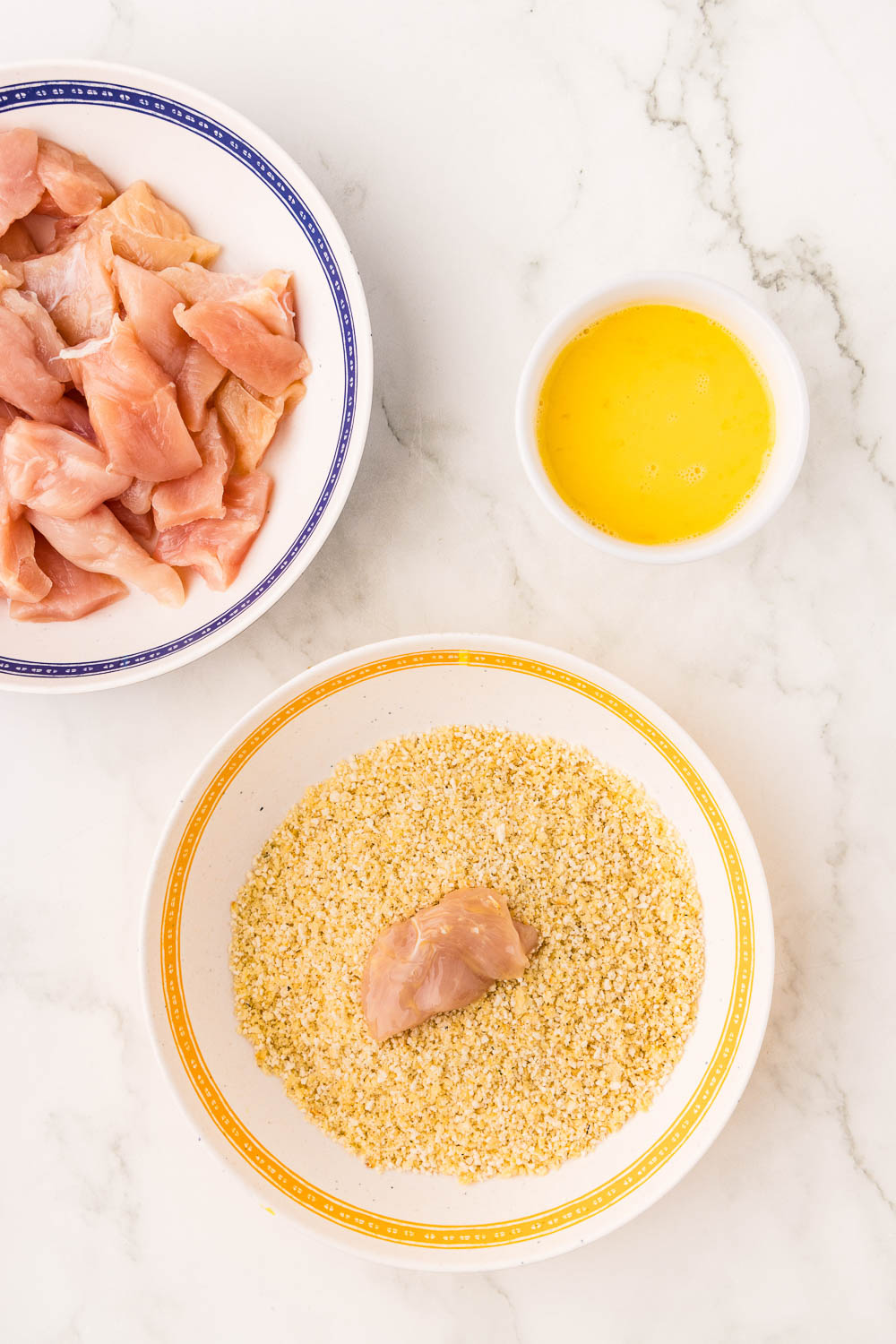 Egg covered Chicken in dish with panko crumbs