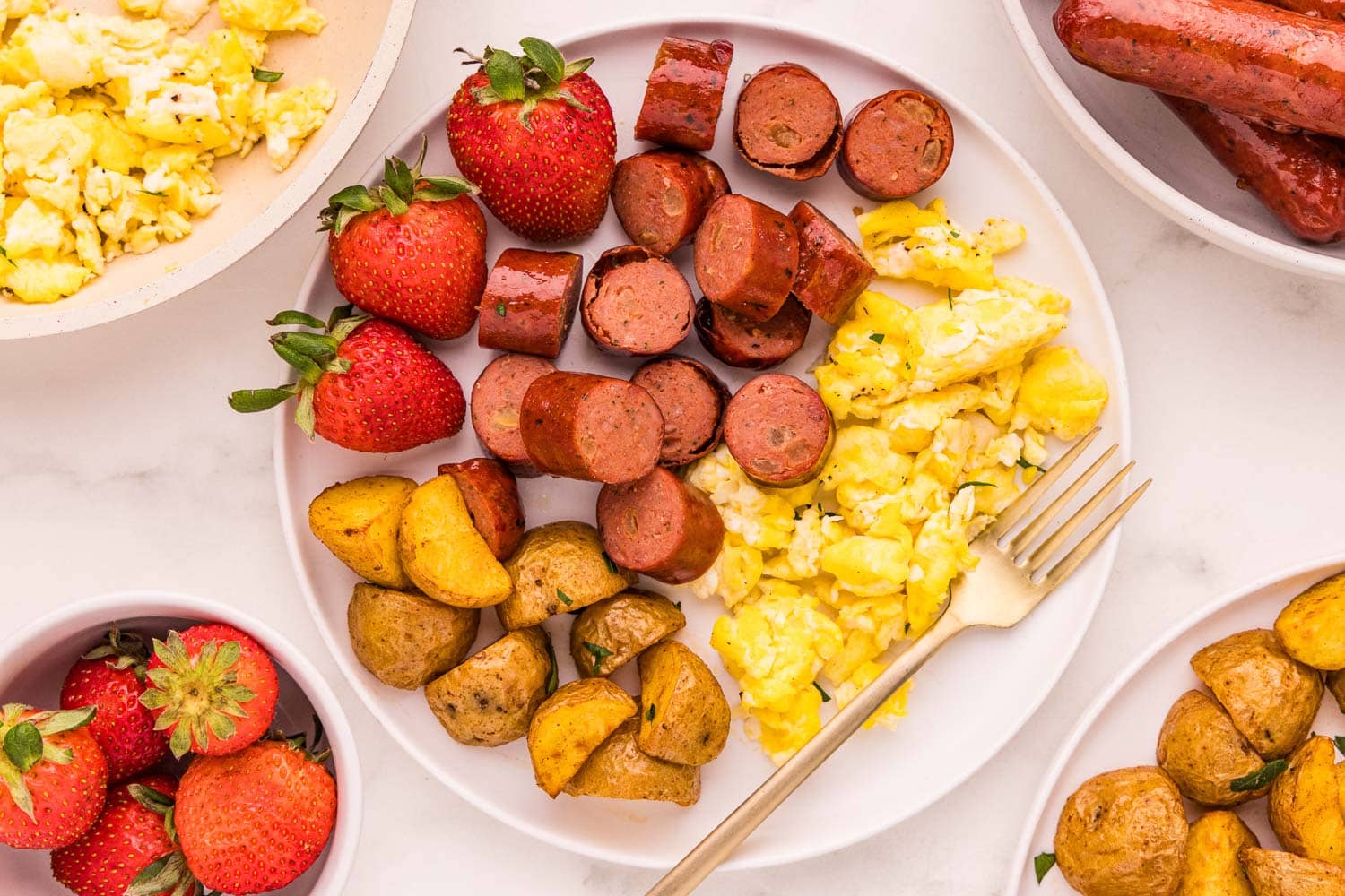 Chopped Air Fryer Chicken Sausage served on a plate with eggs, potatoes, and strawberries