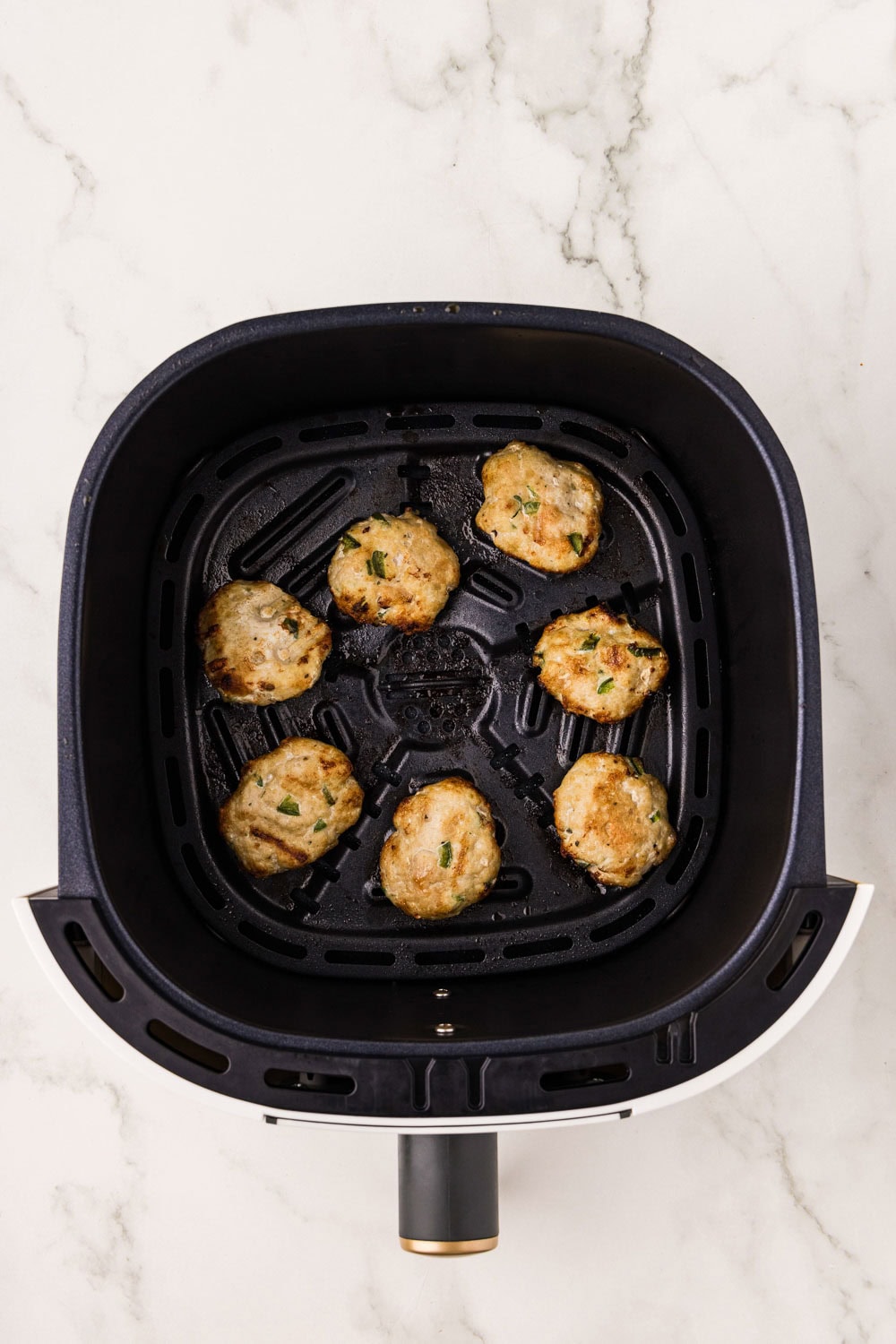 Air Fryer Sausage Patties being cooked in air fryer basket