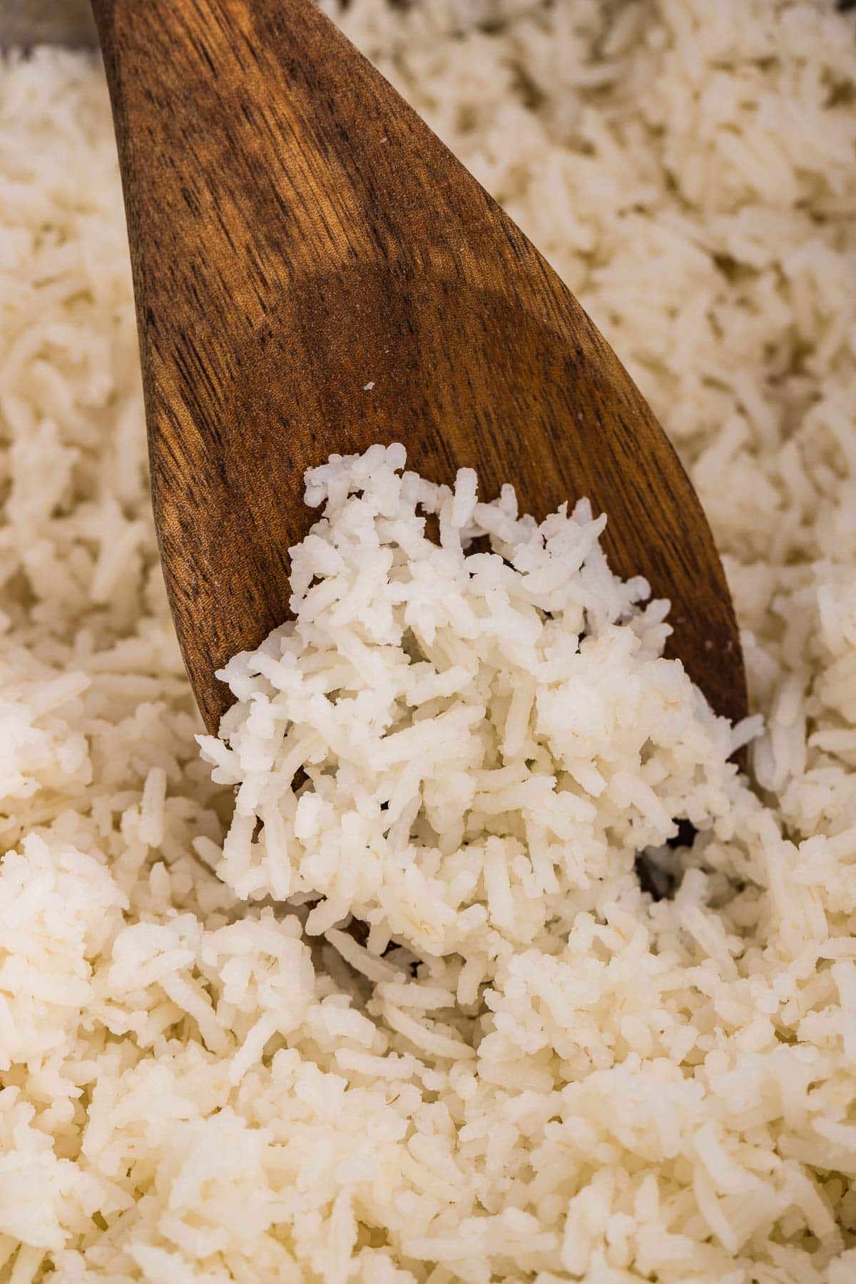 Close up of basmati rice being stirred by wooden spoon