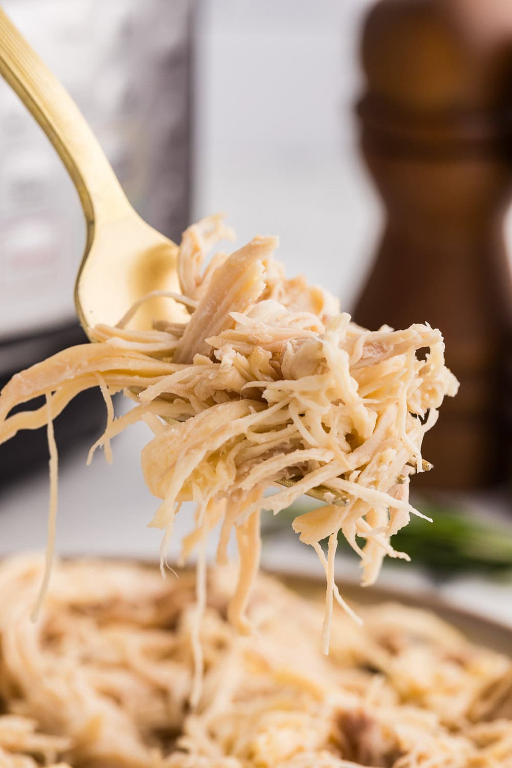 gold fork full of shredded chicken