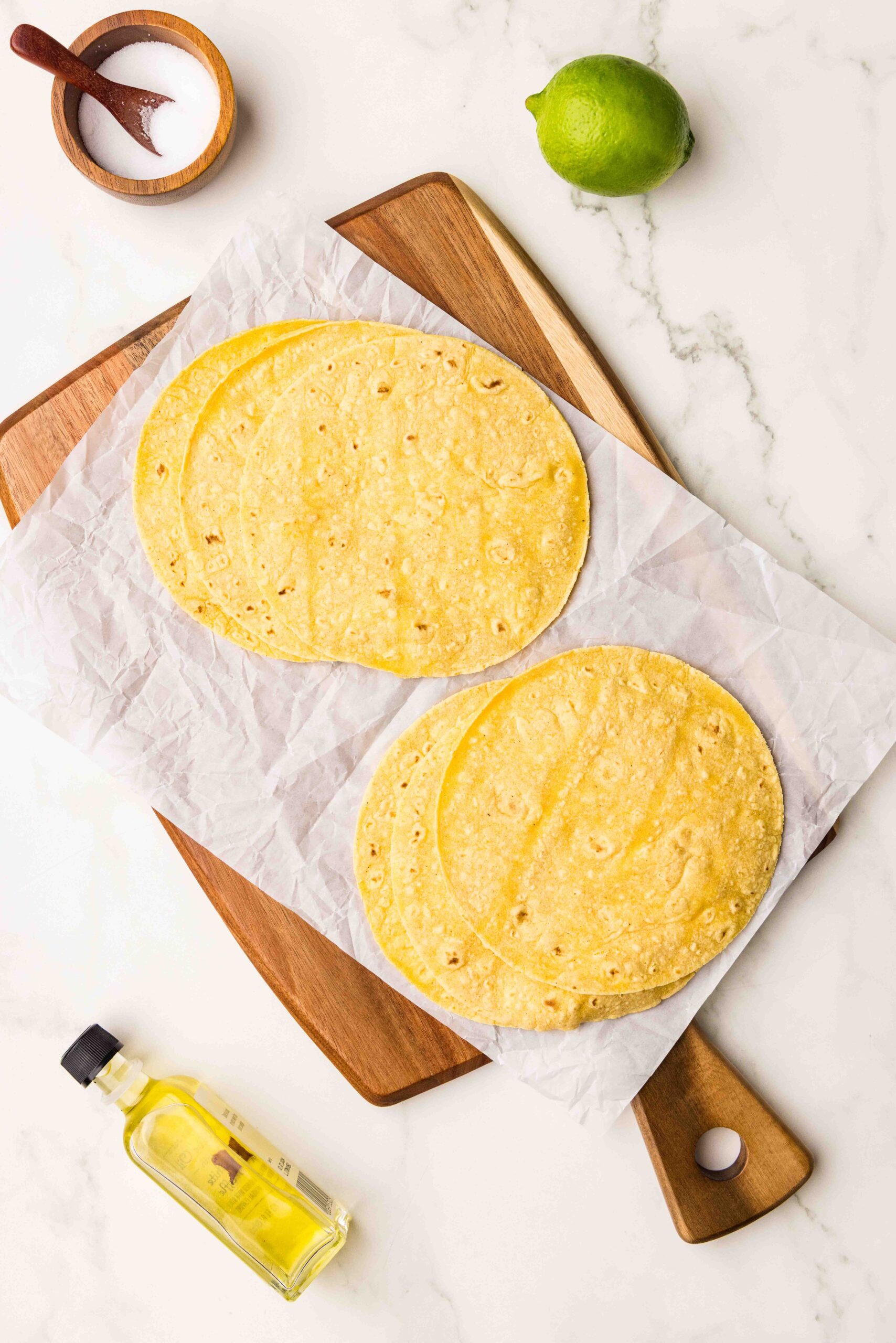 corn tortillas on parchment paper and cutting board