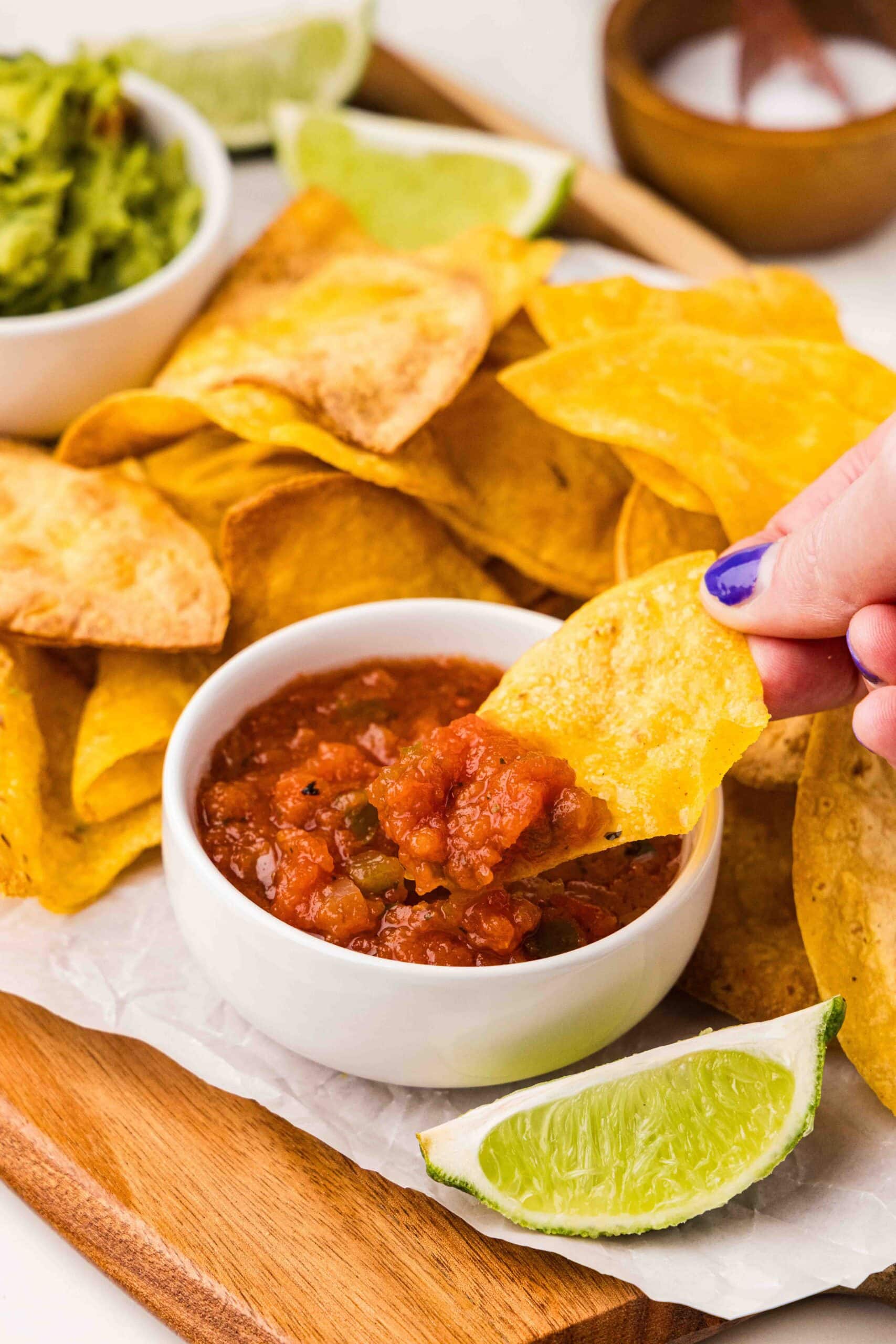 tortilla chips and salsa, guacamole, and lime wedges