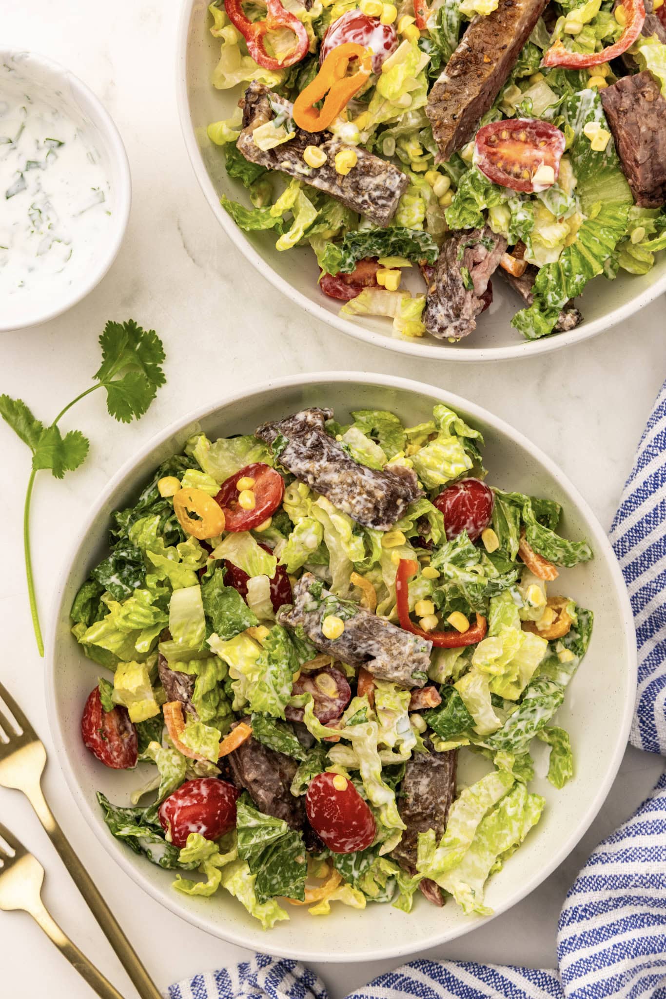 Two bowls of salad with meat and vegetables