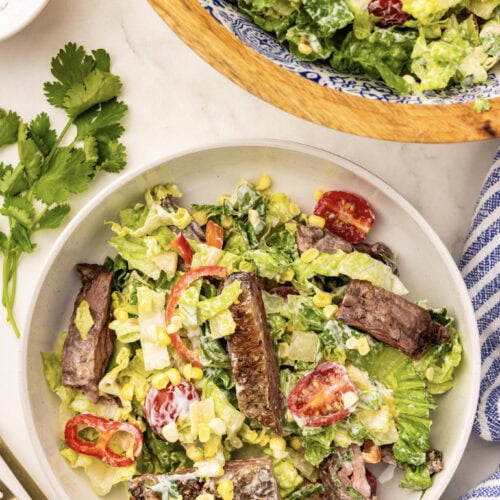 A salad with steak and lettuce on a table