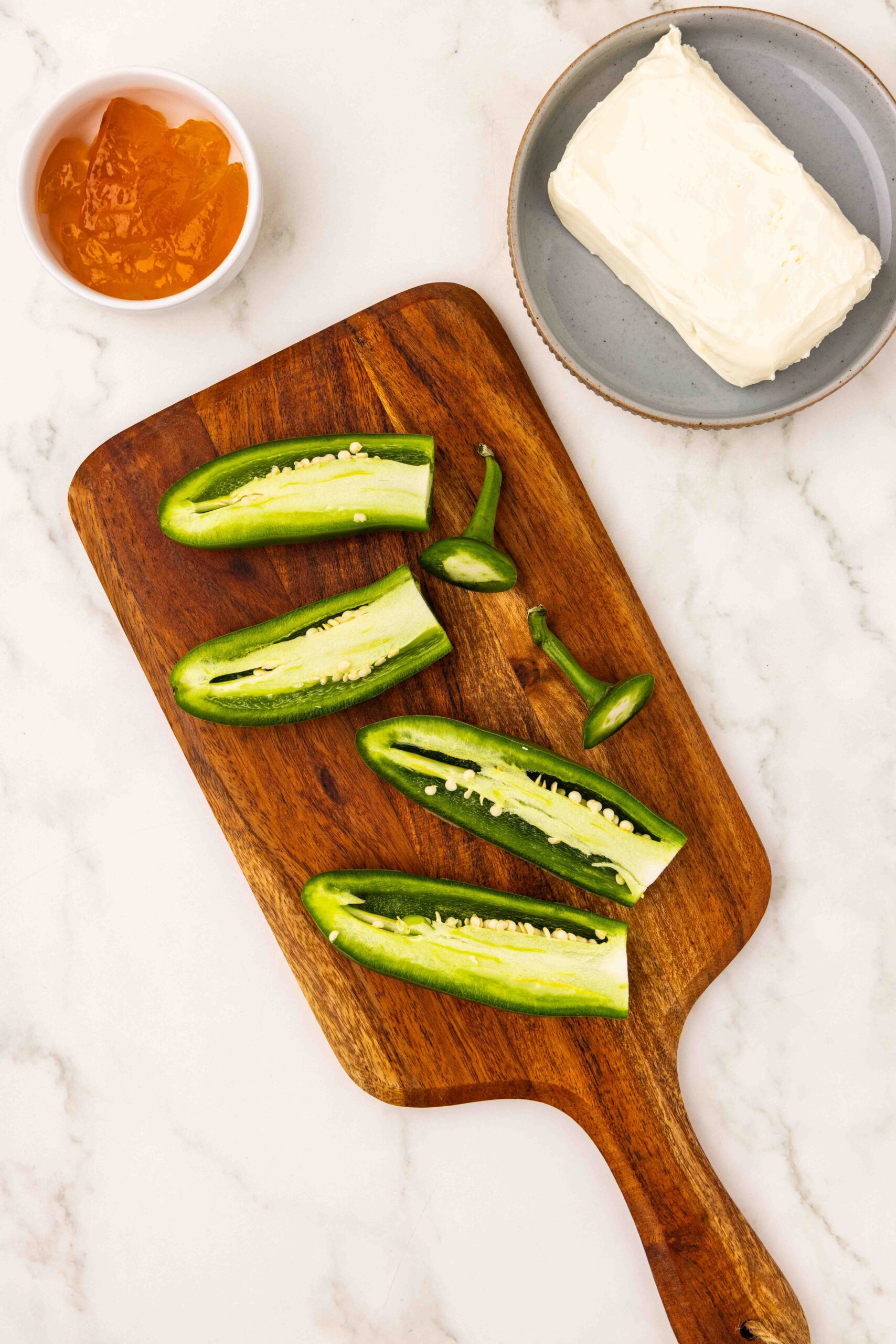 Jalapeño peppers sliced open on cutting board