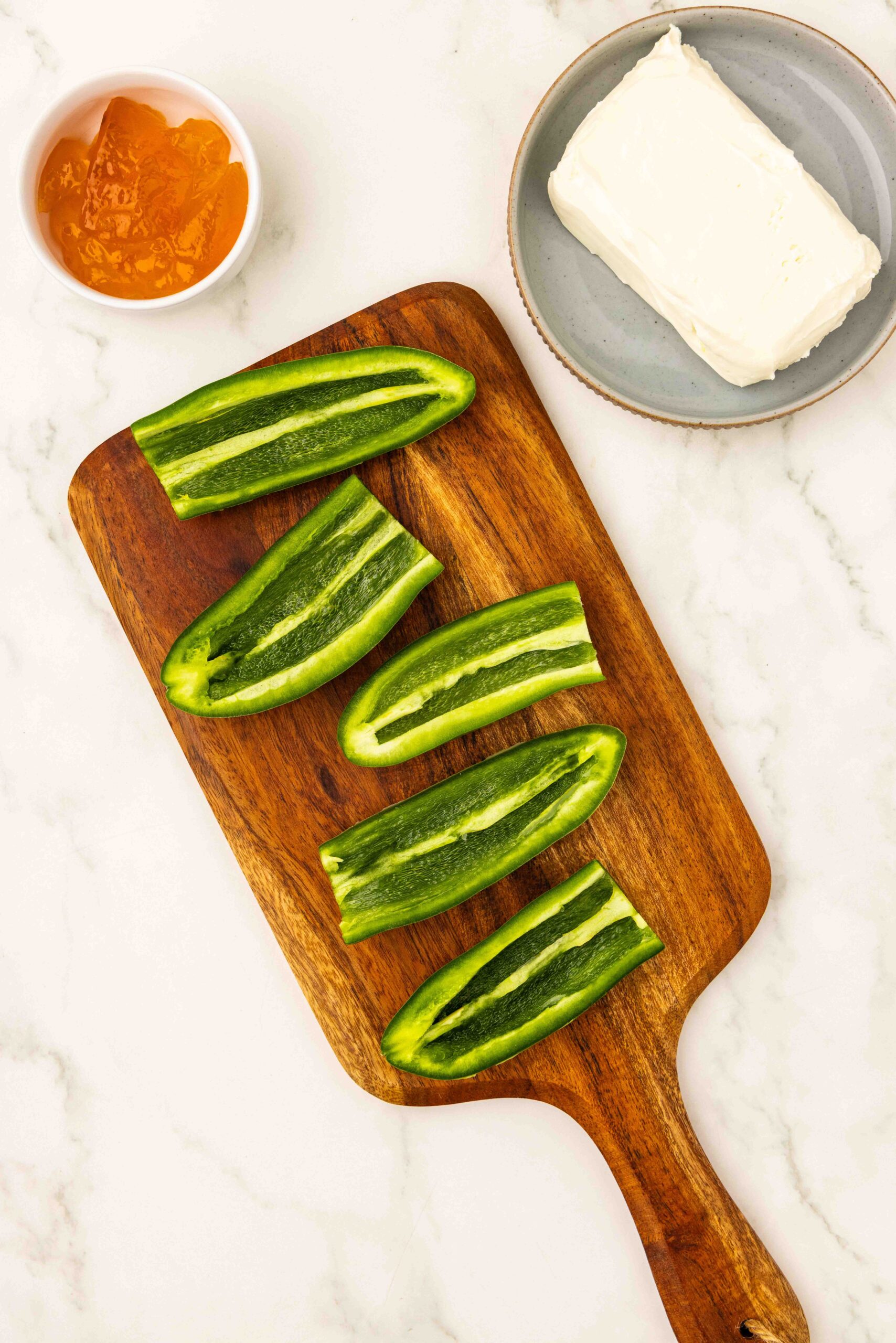 Jalapeño peppers sliced in helf length wise and seeds removed on cutting board