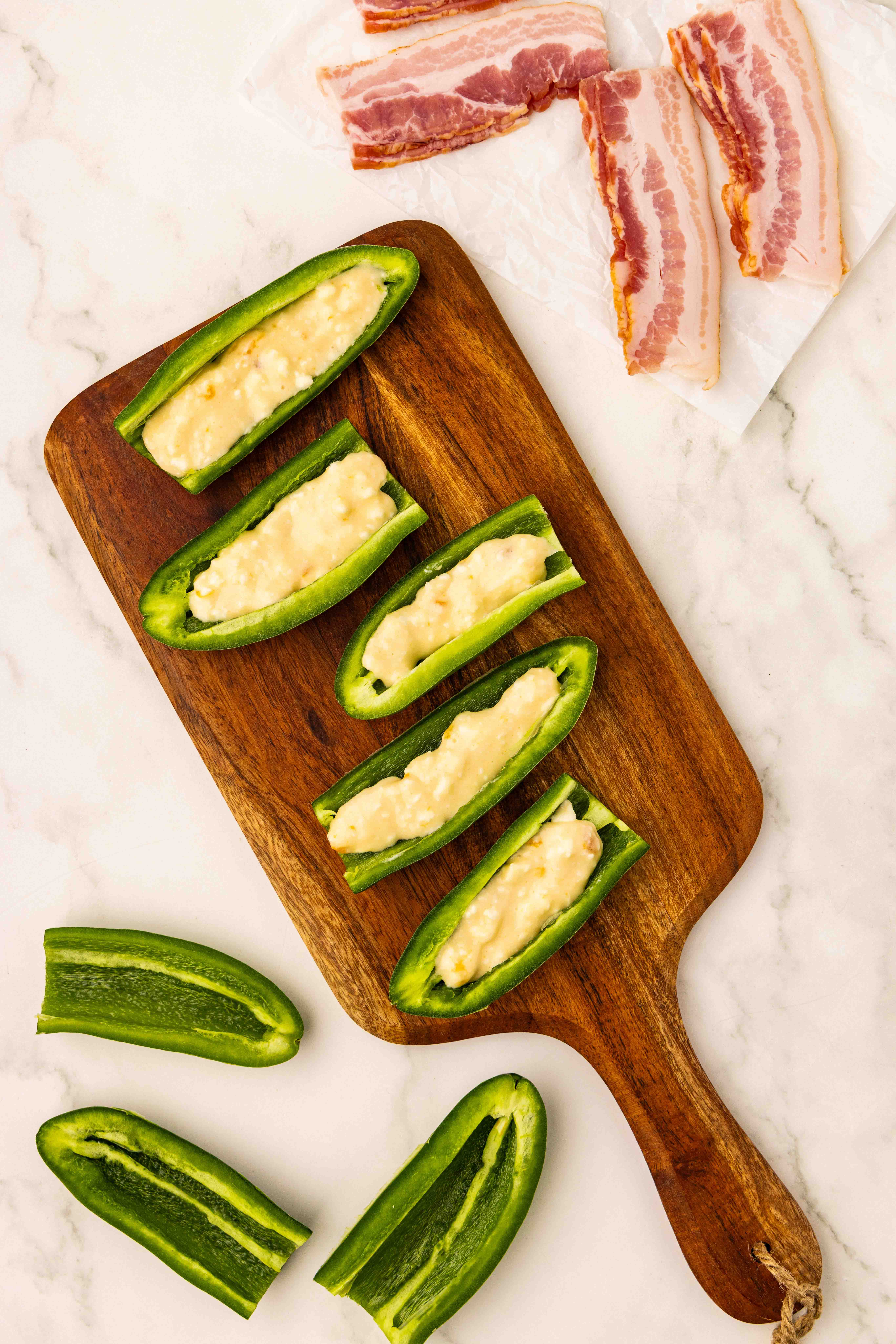 Sliced lengthwise jalapeño peppers on cutting board