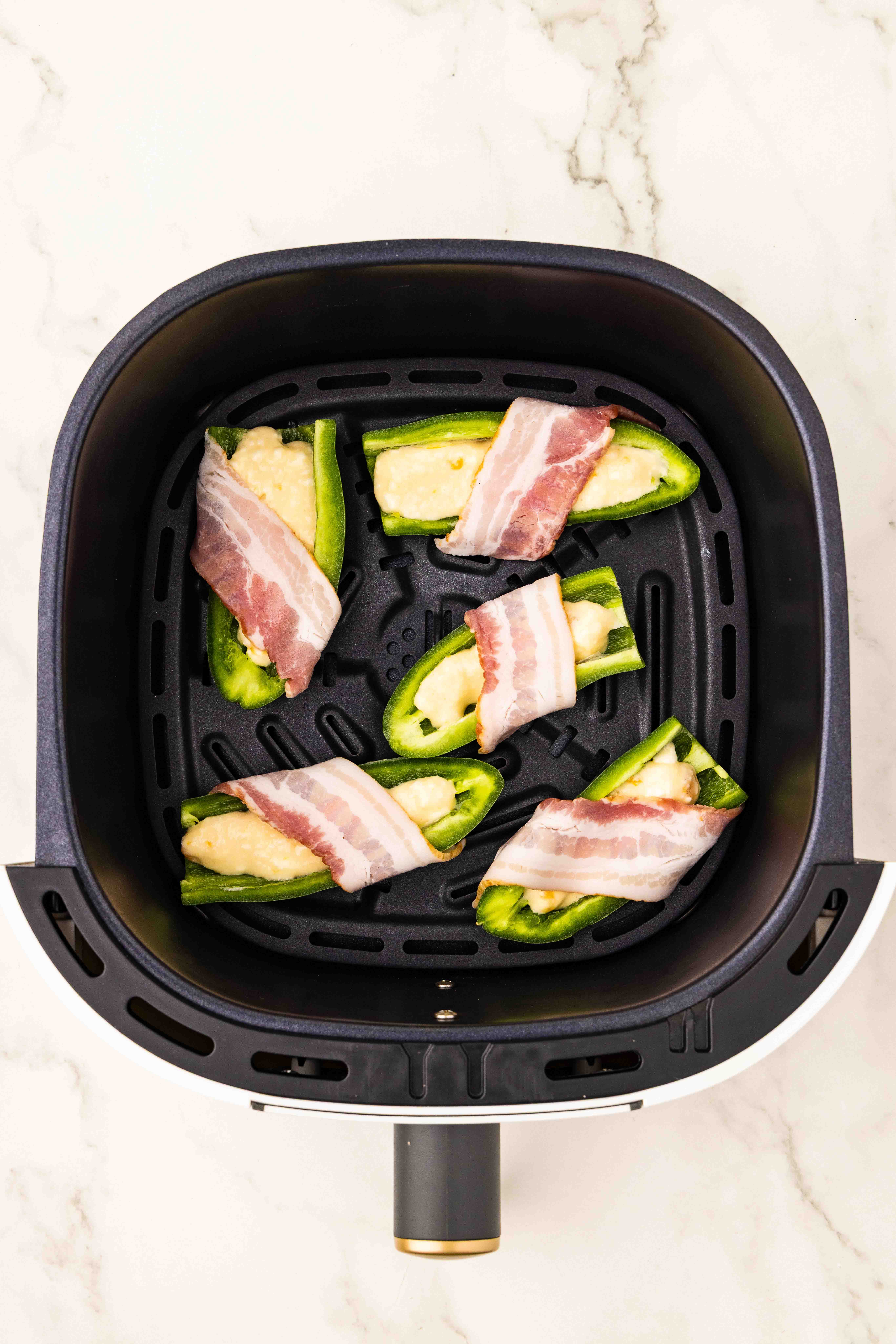 Sliced lengthwise jalapeño peppers in air fryer