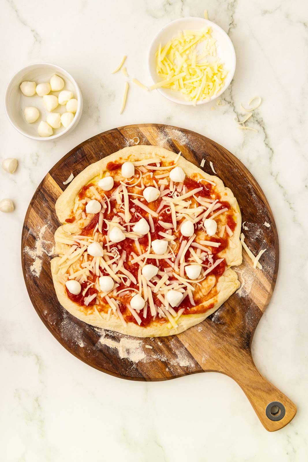 A pizza with tomato sauce on a wooden board