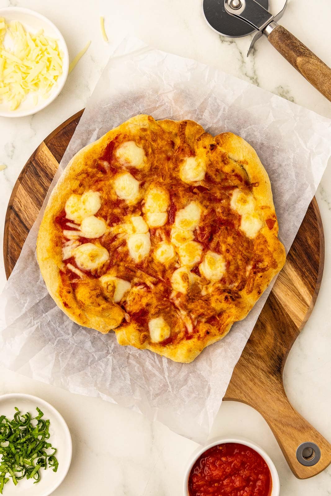 Air fryer pizza with cheese and sauce on a cutting board