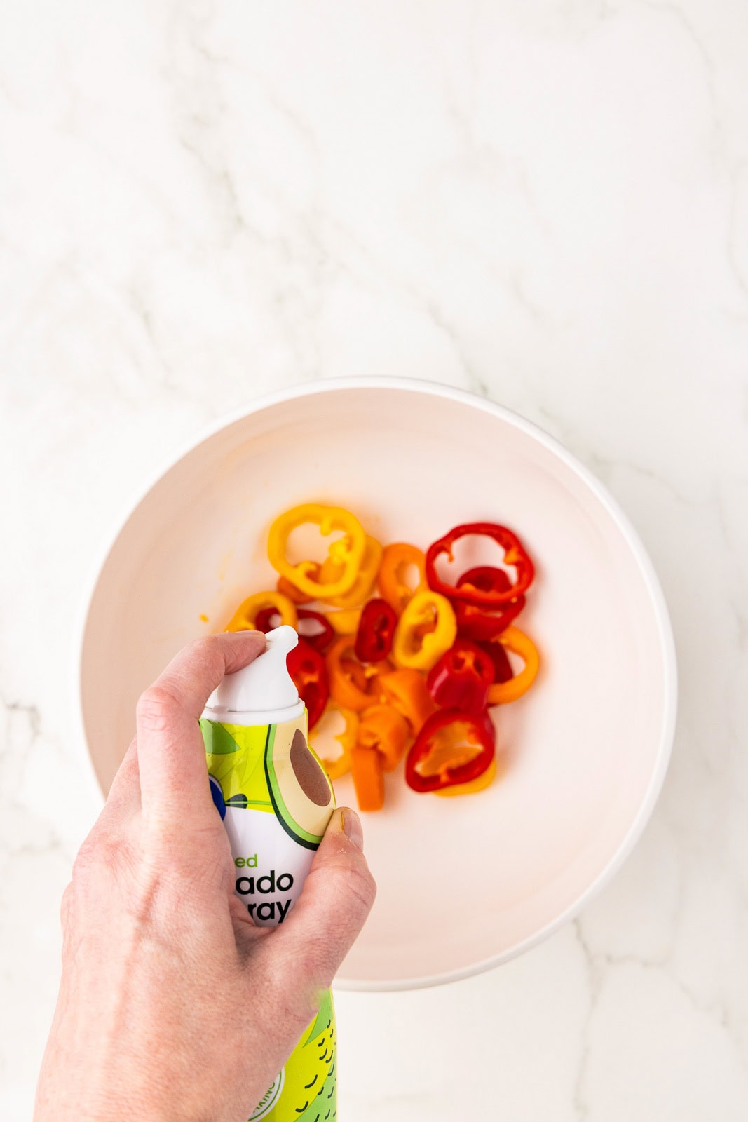white bowl with peppers with spray of avocado spray