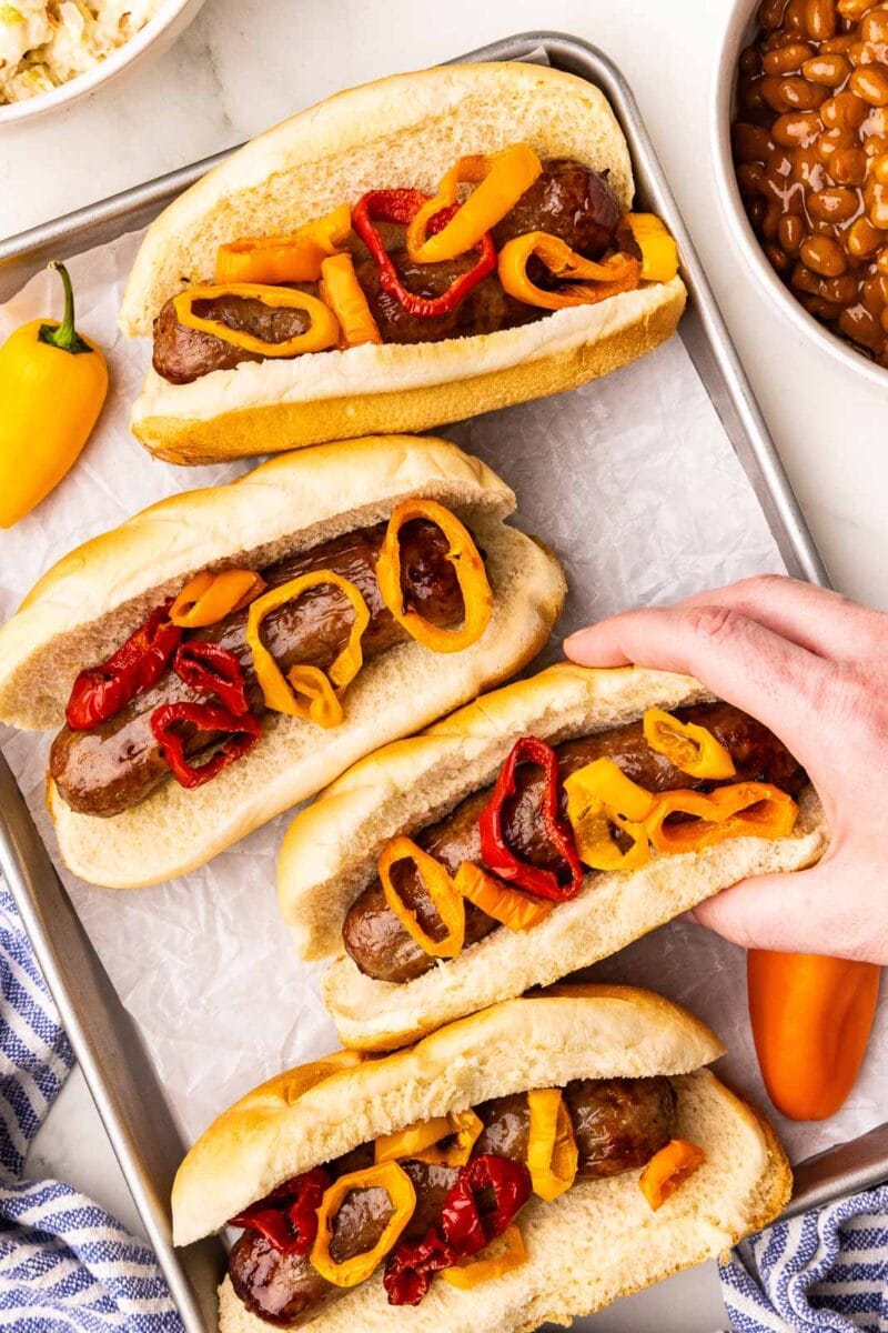 overhead shot of tray with 4 air fried brats with peppers on buns