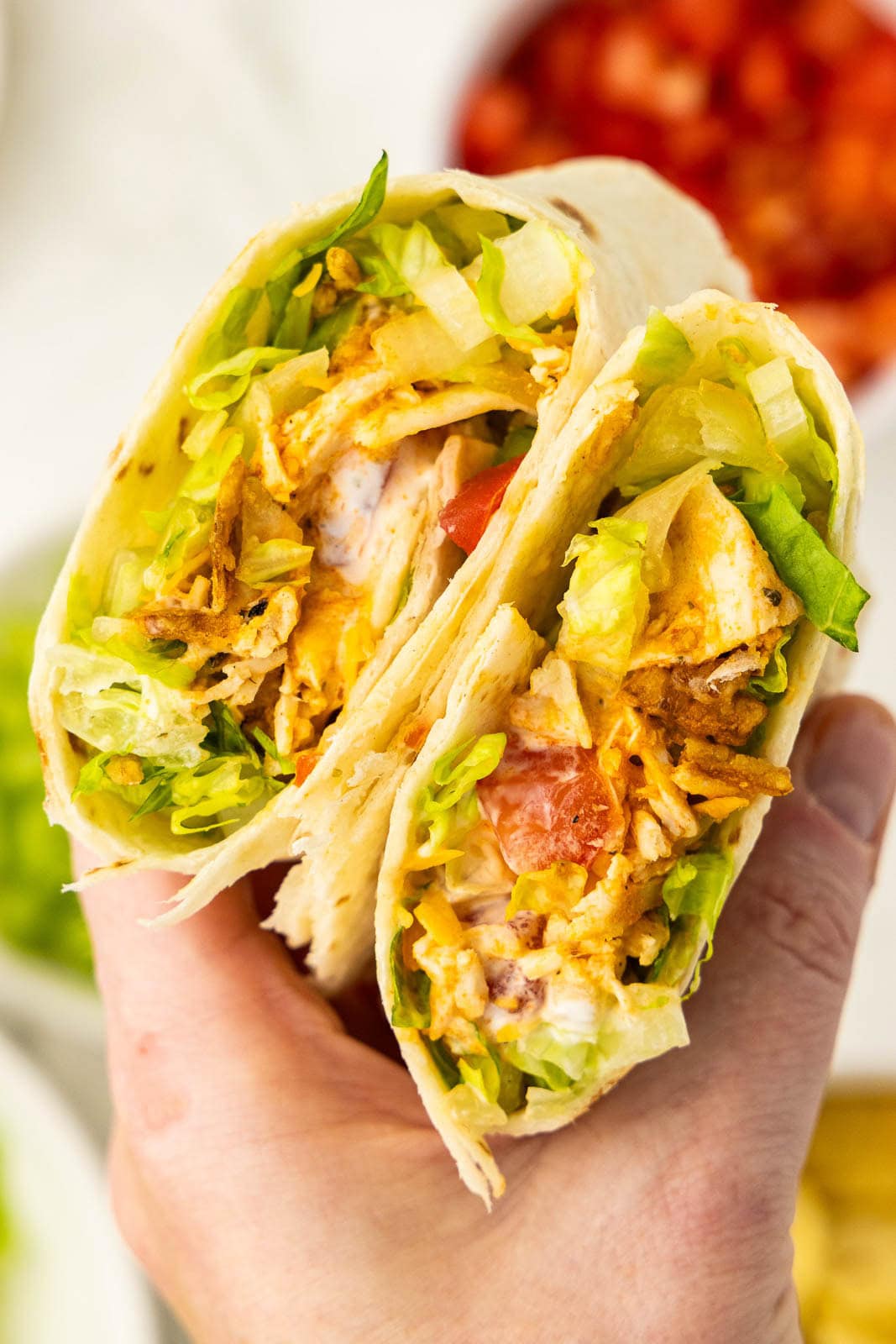 closeup of hand holding cut buffalo chicken wrap