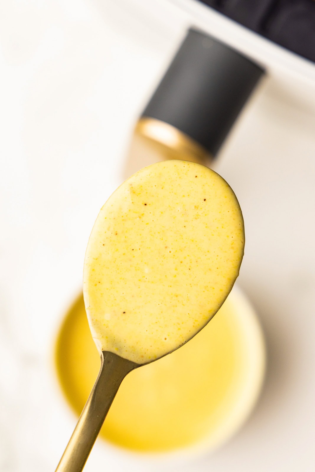 closeup view of spoon containing bbq sauce/mayo mixture, with air fryer in background