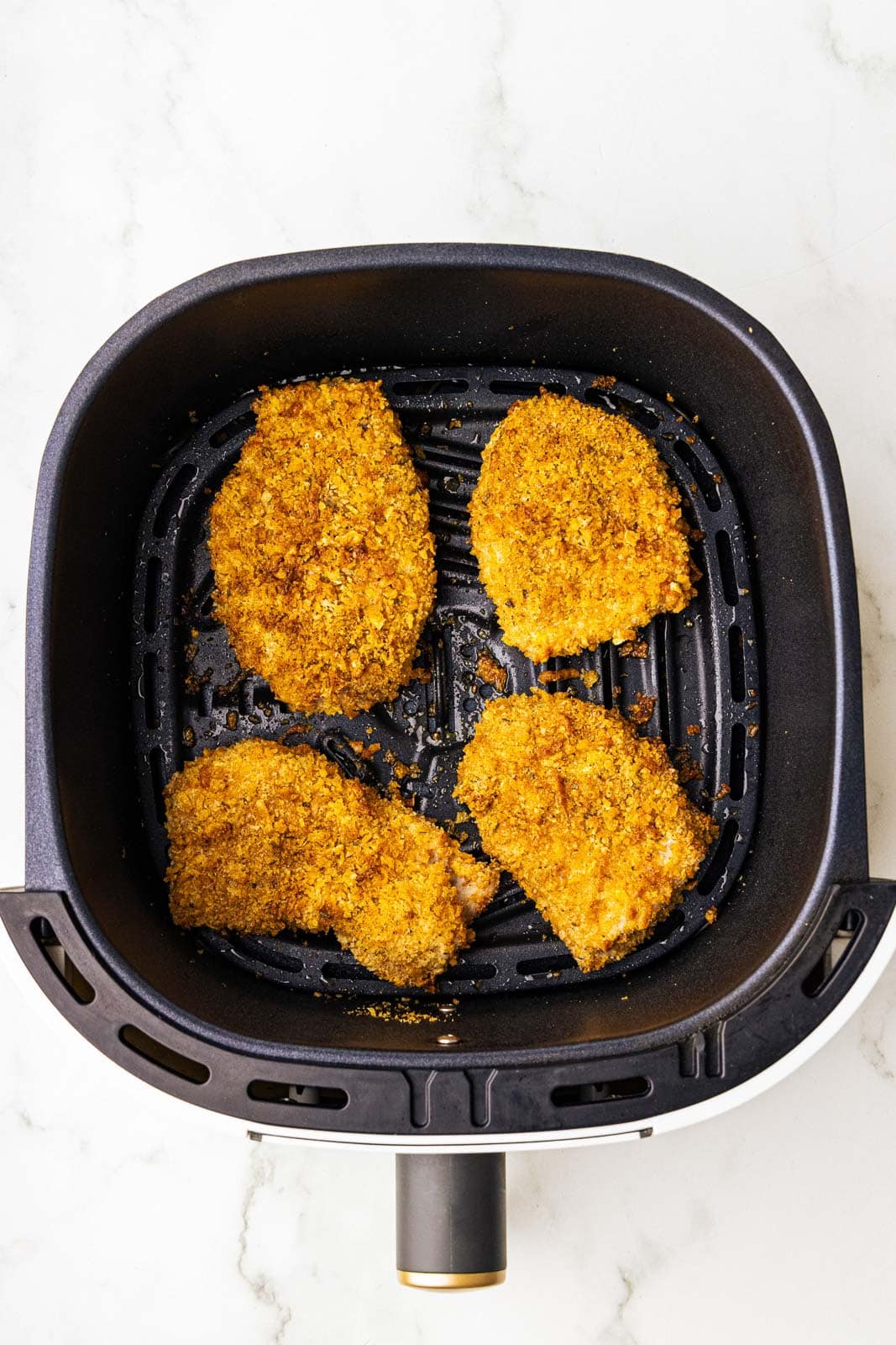 four air fried pork chops in black air fryer