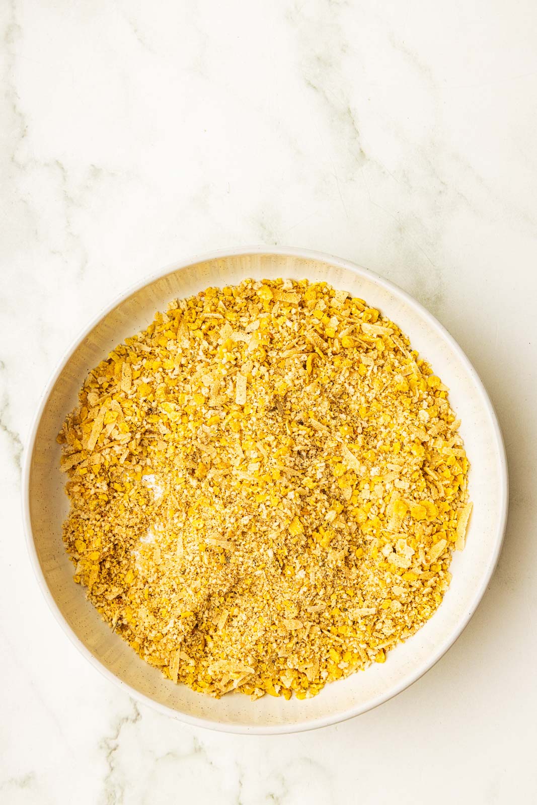 bowl of mixed corn flakes, parmesan cheese, panko bread crumbs, and seasonings