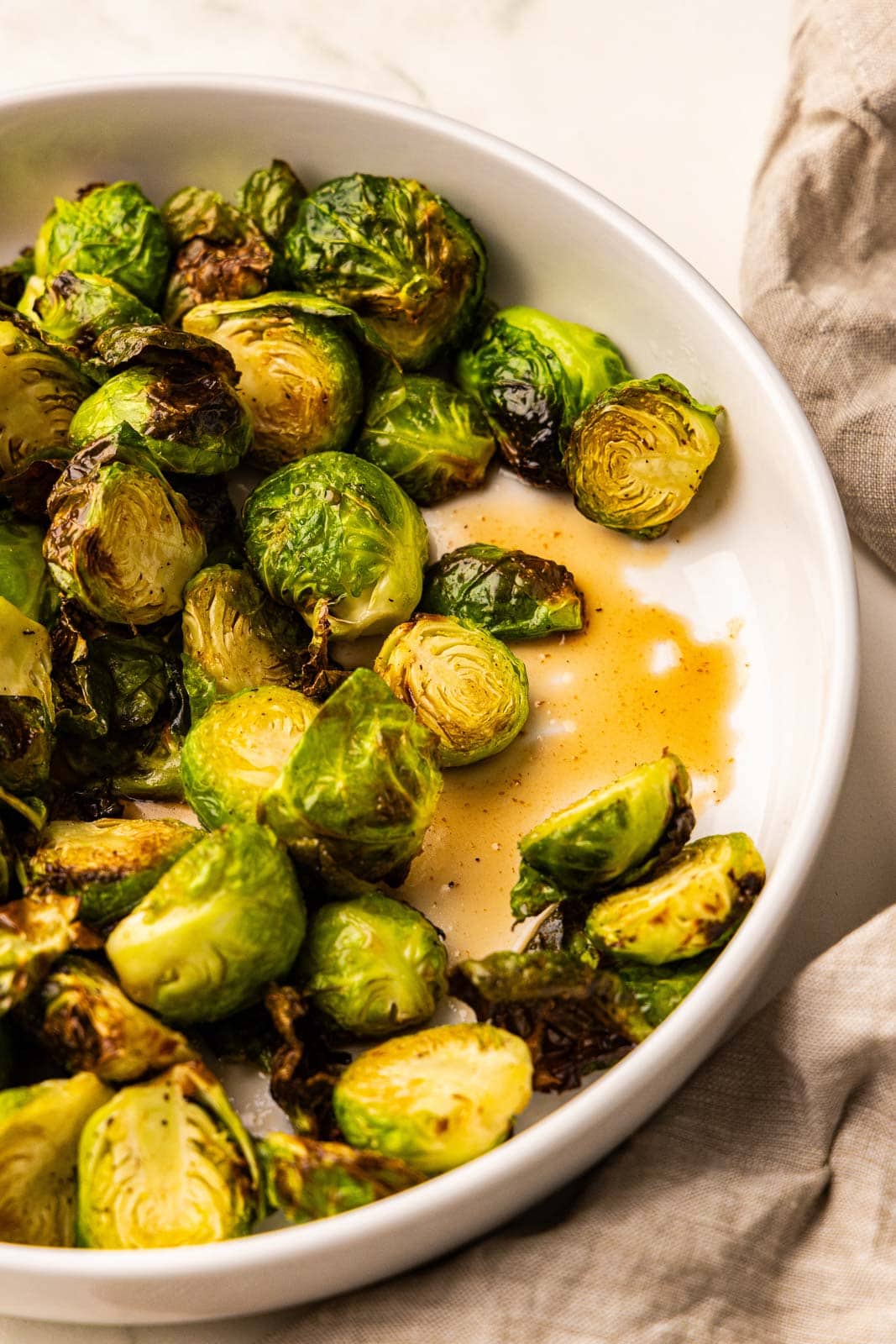 white serving bowl of Brussels sprouts with glaze