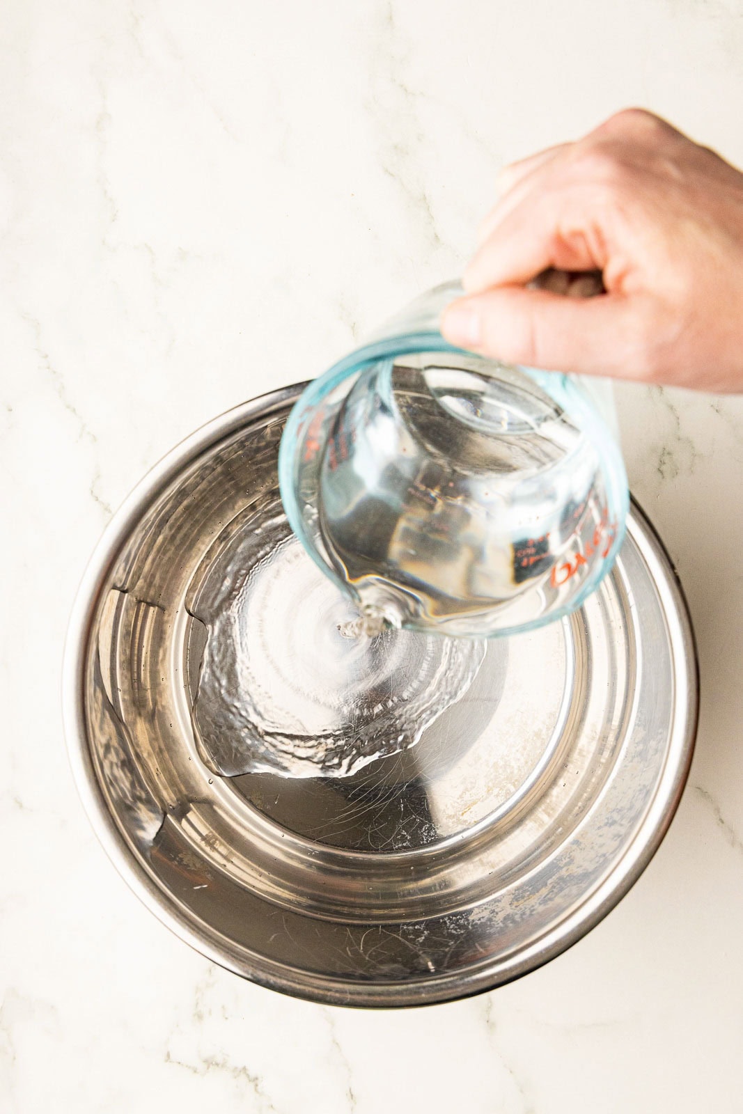 overhead view of hand with water pouring into instant pot