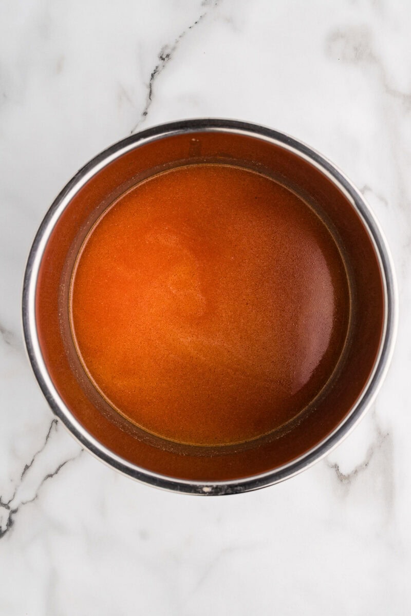 overhead view of instant pot tomato sauce added to pot